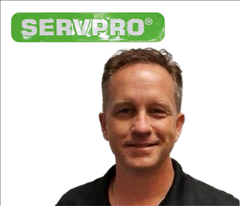 Bill Shook for SERVPRO on wall - male employee in black shirt