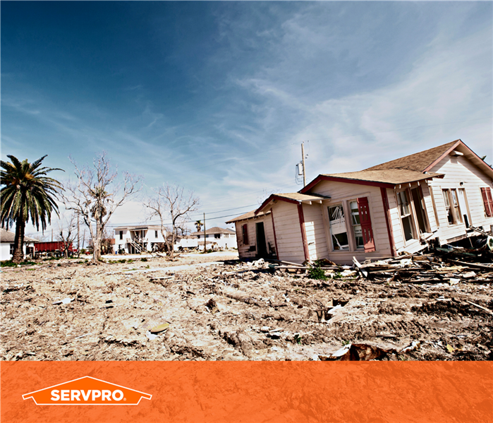 house torn down, rubble, in texas, yellow small house, orange bar of color at bottom, orange SERVPRO logo left corner
